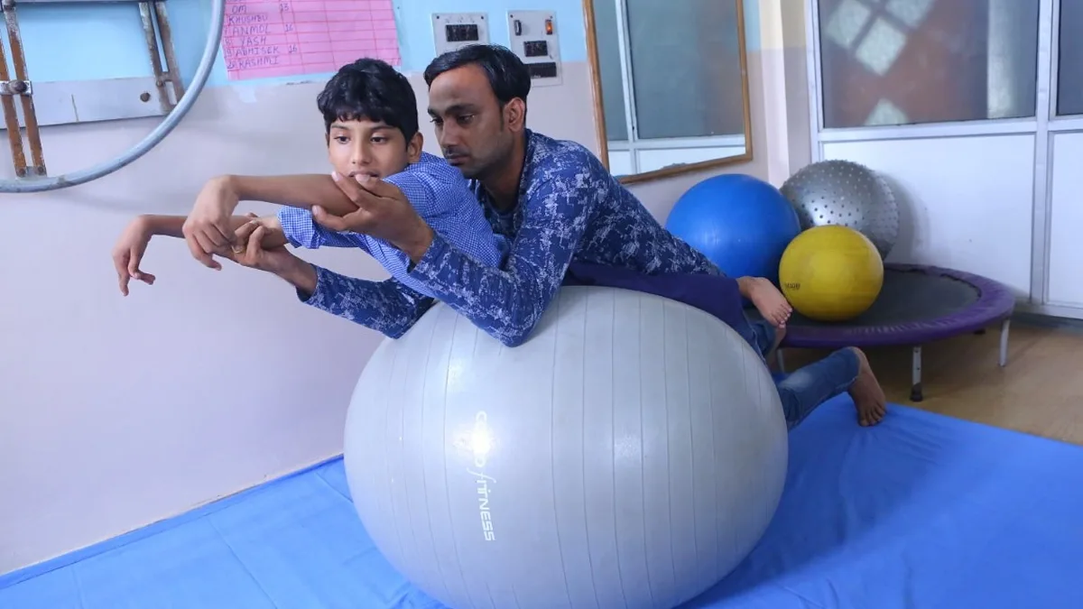 Physiotherapist guiding a young patient through an exercise ball session, the kind of clinical practice you get when you study physiotherapy in Turkey